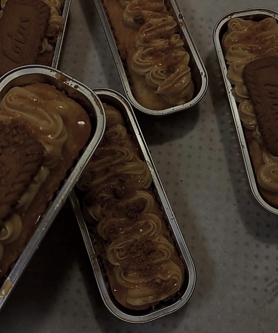Individual dessert trays topped with caramel-colored swirls, crumbs and rectangular cookies